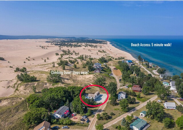 bird's eye view with a water view and a beach view