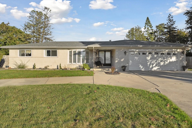 ranch-style home featuring a garage and a front lawn