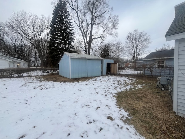 yard covered in snow featuring a storage unit