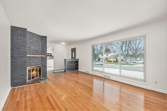 unfurnished living room featuring wood-type flooring and a fireplace