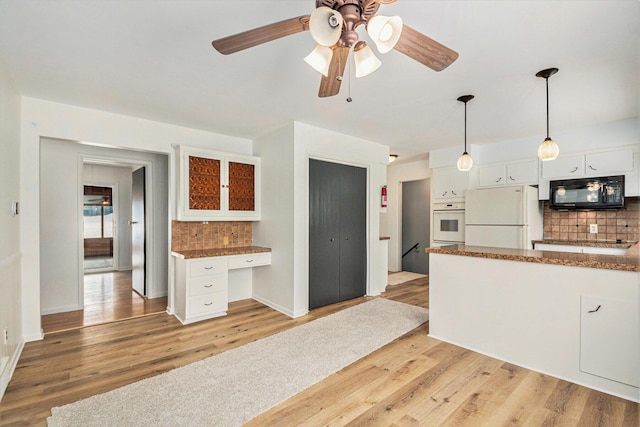 kitchen featuring built in desk, hanging light fixtures, light wood-type flooring, white appliances, and white cabinets