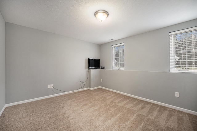 unfurnished room with carpet flooring and a textured ceiling