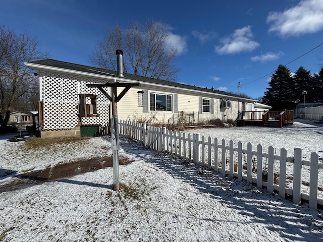 snow covered property with a deck