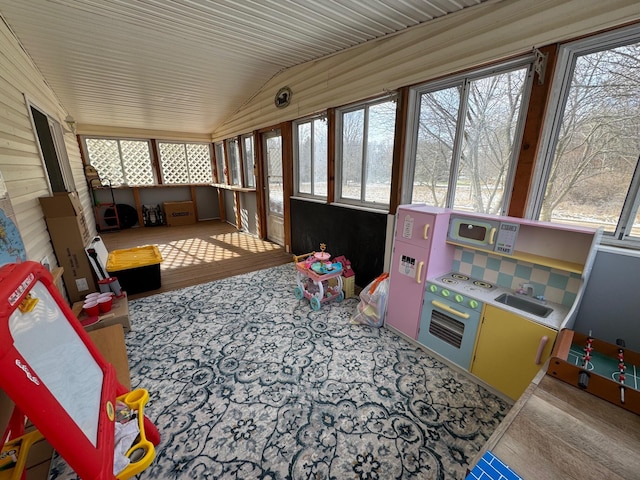 sunroom with a healthy amount of sunlight, sink, and vaulted ceiling