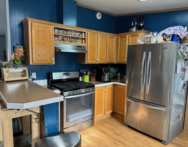 kitchen featuring crown molding, light hardwood / wood-style flooring, and appliances with stainless steel finishes