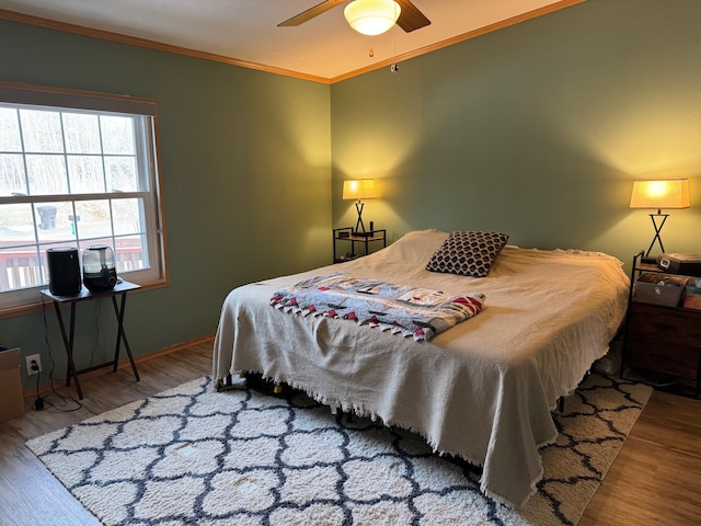 bedroom featuring wood-type flooring, ceiling fan, and crown molding