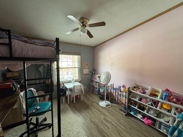 bedroom with hardwood / wood-style flooring, crown molding, ceiling fan, and a textured ceiling