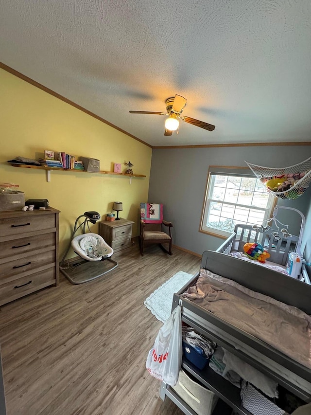 bedroom featuring crown molding, wood-type flooring, a textured ceiling, and vaulted ceiling