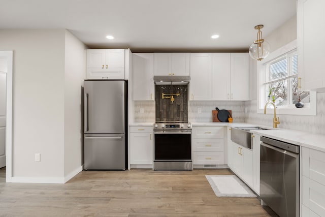 kitchen with tasteful backsplash, appliances with stainless steel finishes, white cabinets, and decorative light fixtures