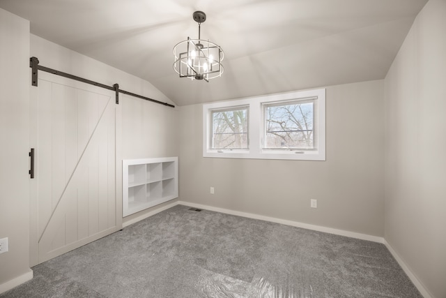 interior space featuring an inviting chandelier, lofted ceiling, a barn door, and carpet