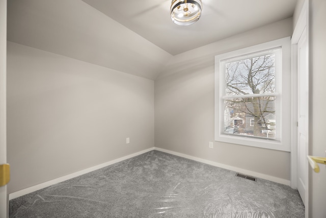 carpeted empty room featuring plenty of natural light and vaulted ceiling