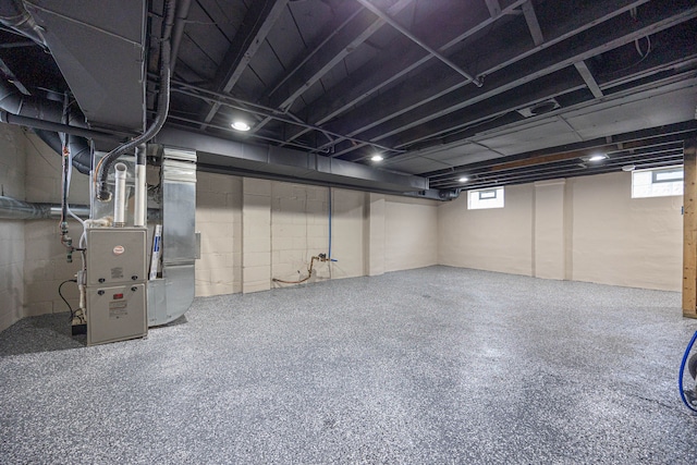 basement with heating unit and a wealth of natural light