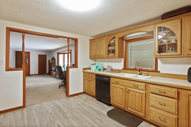 kitchen with sink, dishwasher, a textured ceiling, and light wood-type flooring