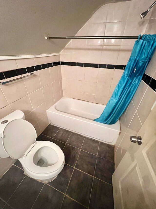 bathroom featuring tile patterned flooring, toilet, tile walls, and shower / bath combo with shower curtain