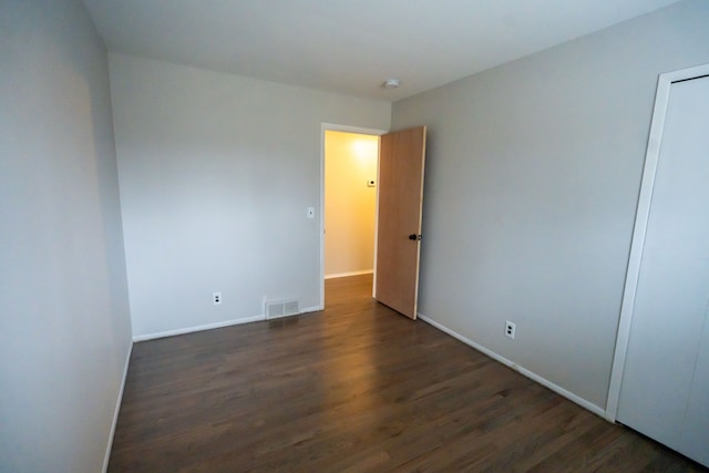 unfurnished room featuring dark wood-type flooring