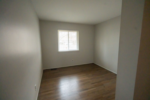 empty room with dark wood-type flooring