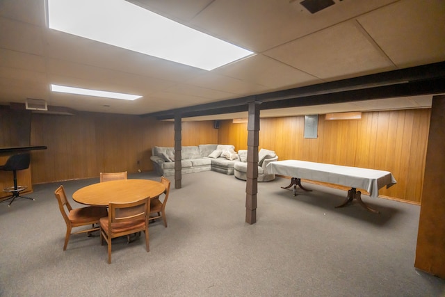 game room with carpet flooring, a paneled ceiling, and wood walls