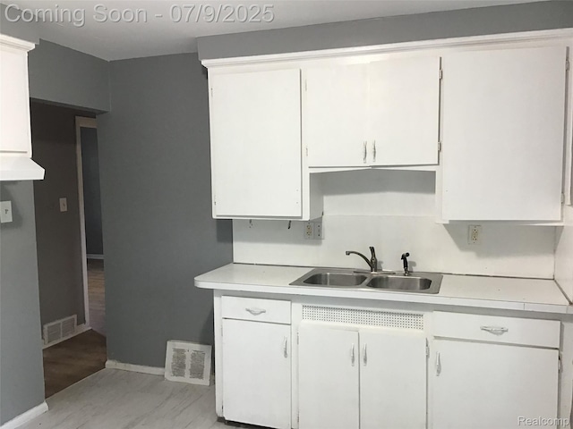19611 W Chicago St, Detroit, MI 48228 - kitchen featuring light countertops, white cabinets, and light wood-type flooring