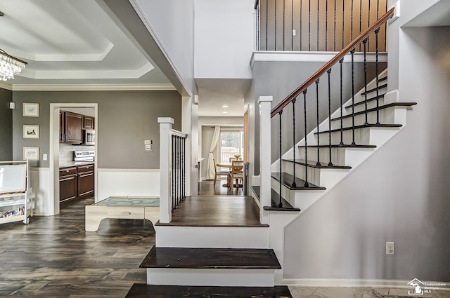 foyer featuring crown molding, a tray ceiling, dark hardwood / wood-style floors, and an inviting chandelier