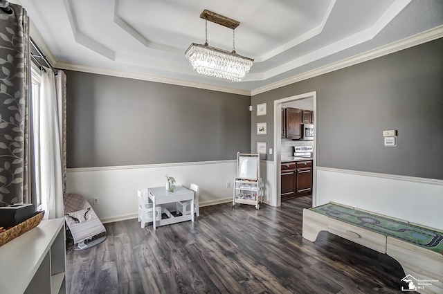 interior space featuring a raised ceiling, crown molding, dark wood-type flooring, and a chandelier