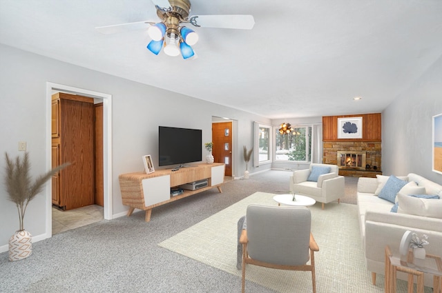 carpeted living room featuring ceiling fan and a fireplace