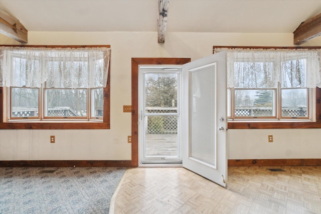 doorway to outside featuring light parquet flooring and beam ceiling