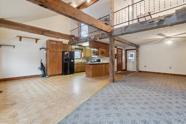 kitchen featuring black fridge, a wealth of natural light, high vaulted ceiling, and beamed ceiling