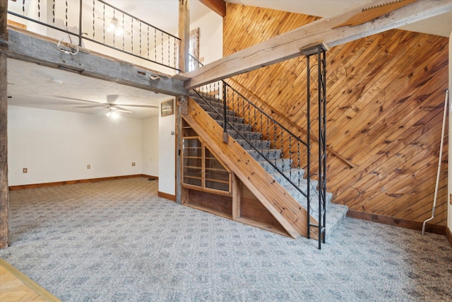 interior space featuring carpet floors, high vaulted ceiling, and wood walls