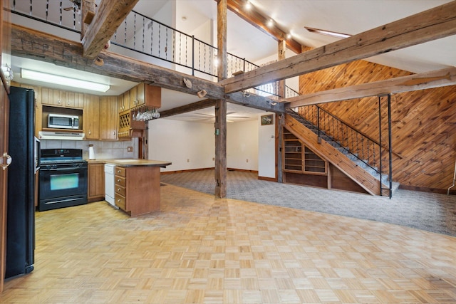 kitchen featuring high vaulted ceiling, beamed ceiling, black appliances, light parquet floors, and kitchen peninsula