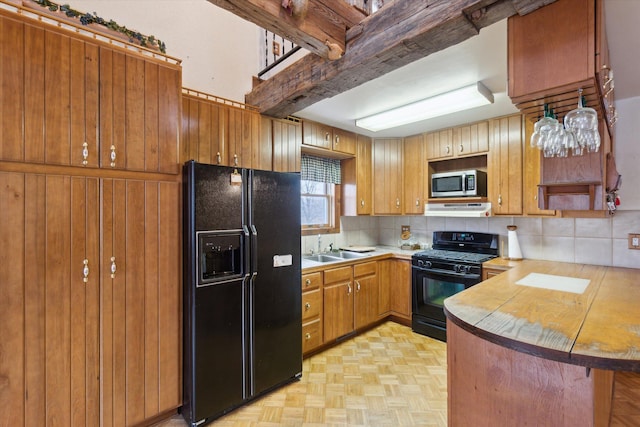 kitchen with beam ceiling, black appliances, decorative backsplash, kitchen peninsula, and light parquet flooring