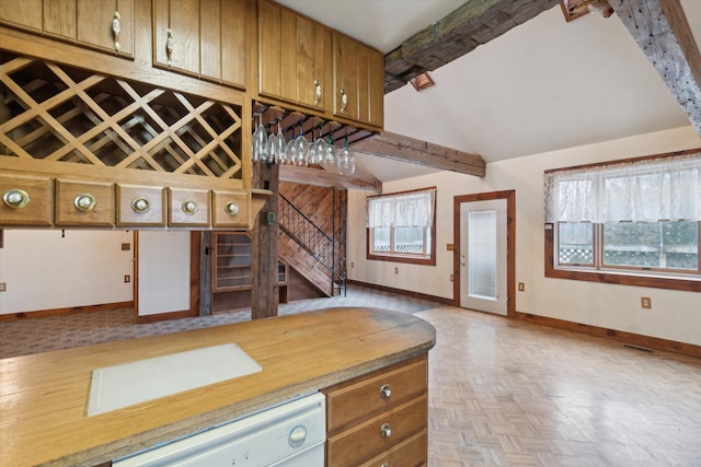 kitchen featuring white dishwasher, vaulted ceiling with beams, plenty of natural light, and light parquet flooring