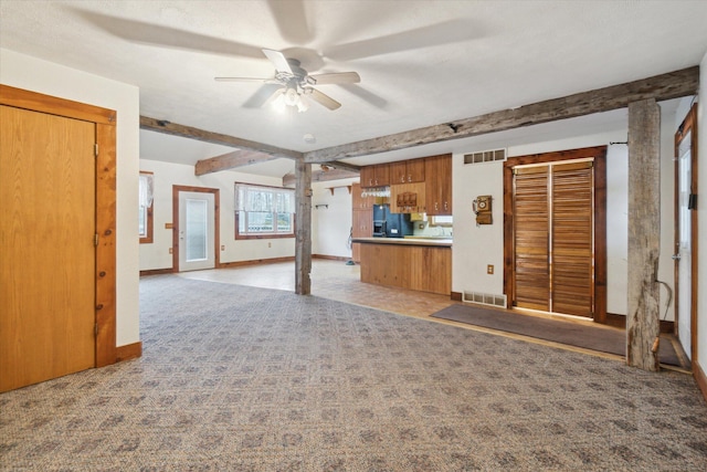 unfurnished living room with ceiling fan, carpet, and beam ceiling