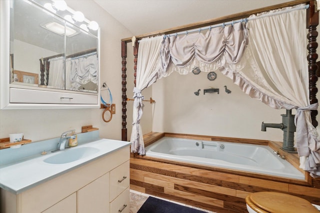 bathroom with toilet, vanity, and tiled bath