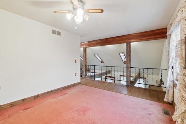 empty room featuring lofted ceiling with beams, carpet flooring, and ceiling fan