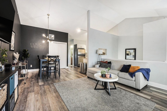 living room with dark wood-type flooring, high vaulted ceiling, and a chandelier