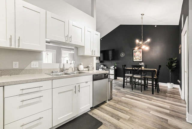 kitchen with sink, hanging light fixtures, stainless steel dishwasher, light hardwood / wood-style floors, and white cabinets