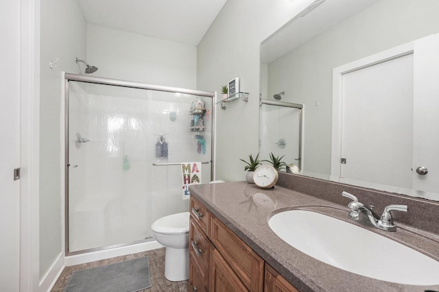 bathroom with vanity, toilet, and a shower with shower door