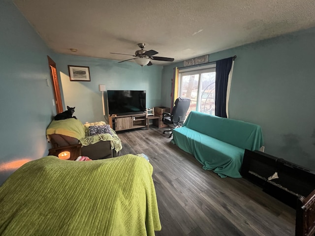 living room featuring dark hardwood / wood-style flooring, ceiling fan, and a textured ceiling