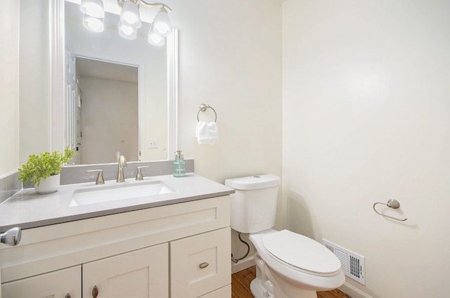 bathroom with vanity, hardwood / wood-style floors, and toilet