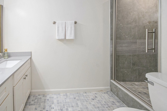 bathroom featuring vanity, toilet, and a shower with door