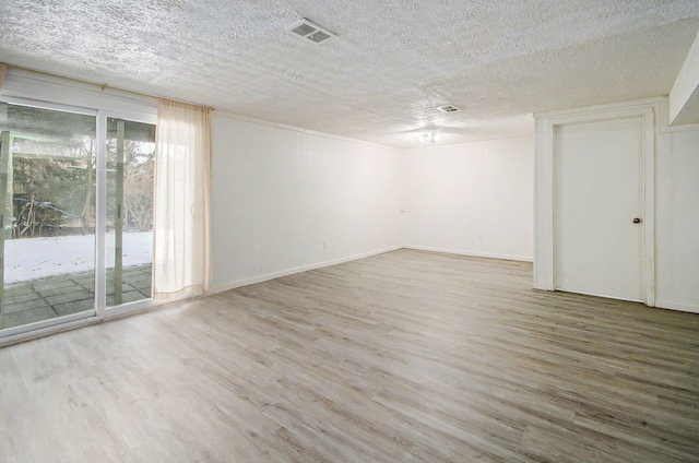 unfurnished room featuring wood-type flooring and a textured ceiling