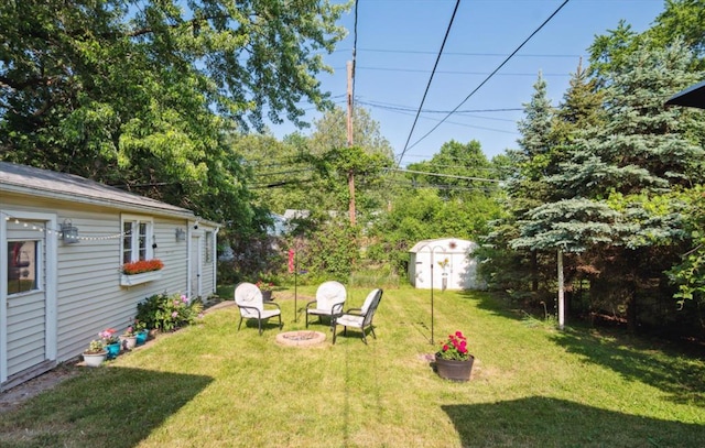 view of yard with a storage shed and a fire pit