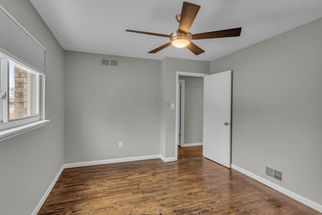 spare room with dark hardwood / wood-style floors and ceiling fan