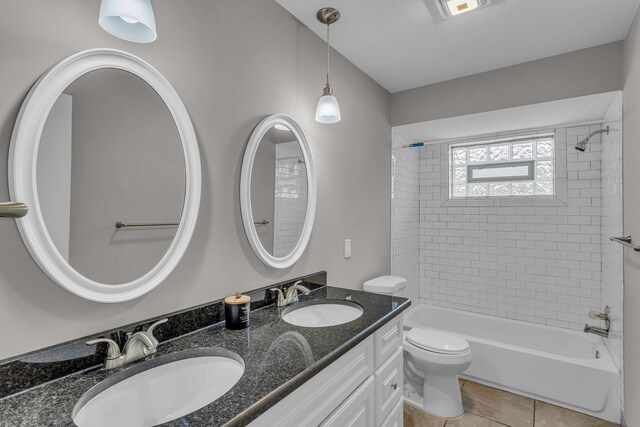 full bathroom featuring tiled shower / bath combo, vanity, tile patterned floors, and toilet