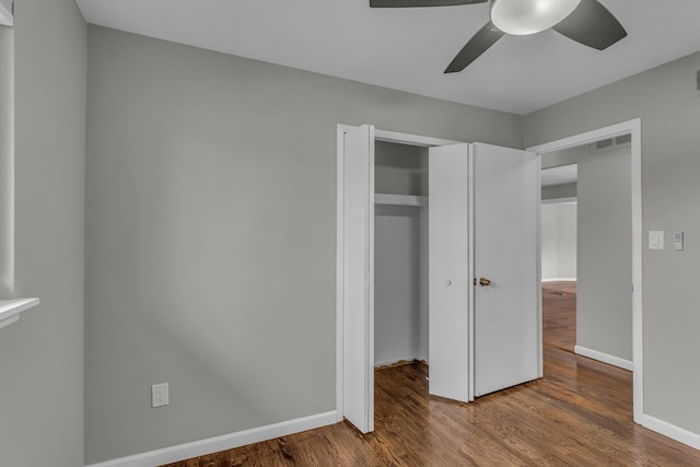 unfurnished bedroom with hardwood / wood-style flooring, ceiling fan, and a closet