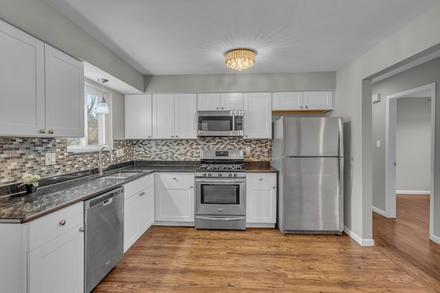 kitchen featuring white cabinetry, stainless steel appliances, sink, and light hardwood / wood-style floors