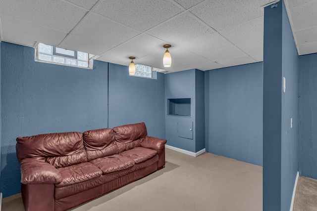 carpeted living room with a paneled ceiling