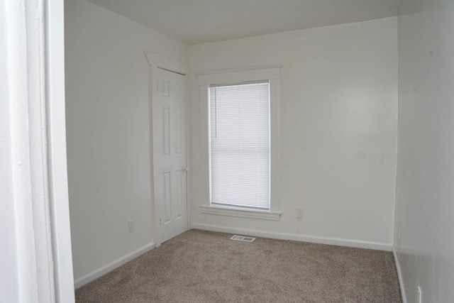 unfurnished room featuring light carpet