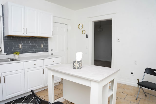 kitchen featuring white cabinetry, sink, decorative backsplash, and light tile patterned flooring