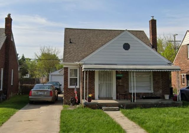 bungalow with a porch, a garage, and a front yard